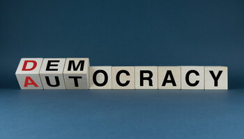 Letter blocks spell out democracy or autocracy from different angles