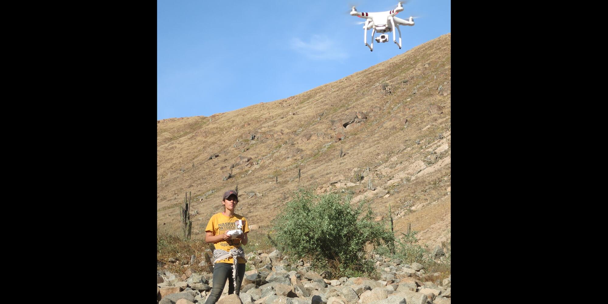 Picture of CLACS associate director Kasia Szremski flying a drone over a dig site in Peru