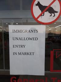 Sign on door saying immigrants unallowed entry in market